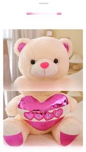 Detailed view of plush teddy bear with pink embroidered Love heart and soft velvet accents