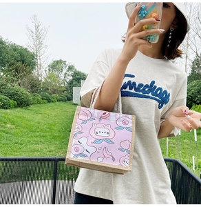 Detail of canvas tote bag with peach and cat print featuring durable cotton rope handles