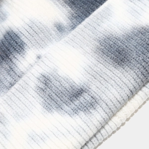 Dettaglio macro di un cappello in maglia tie-dye per bambini con trama a coste morbida