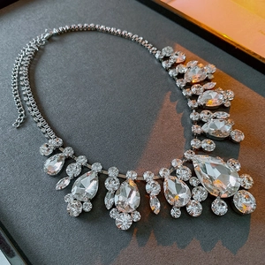 Macro shot of silver statement necklace featuring crystal teardrop pendants and link chain
