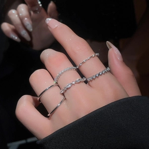 Close-up of sparkling zircon geometric silver rings set on hand with luxury lighting