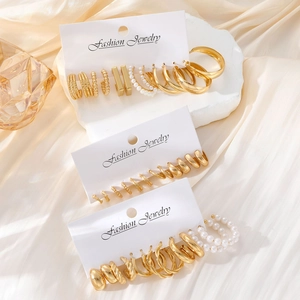 8-piece set of trendy gold geometric earrings and faux pearl studs on white silk