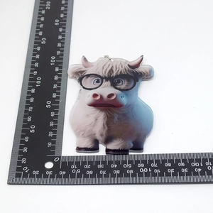 Detailed size view of an 8x7.5cm acrylic cartoon cow charm with glasses and chain
