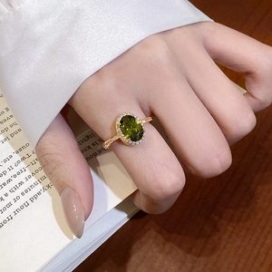 Elegantly worn 18k gold plated ring featuring an oval green zircon and pavé setting