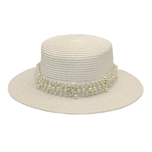 Détail du chapeau de paille à haut plat avec élégantes décorations de perles