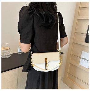 Detail of white leather and beige woven half-moon bag with elegant gold metal clasp