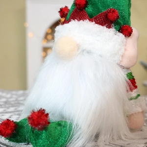 Close-up of green glitter hat and soft white plush beard on Christmas gnome doll