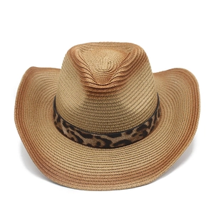 Detailed view of woven straw cowboy hat featuring leopard print band and curved brim