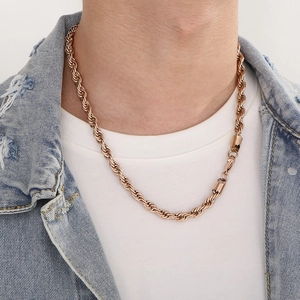 Close-up of a rose gold twisted rope chain necklace worn by a model in casual denim
