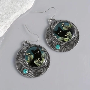 Detailed close-up of retro cat earrings with turquoise accent and vintage alloy frame