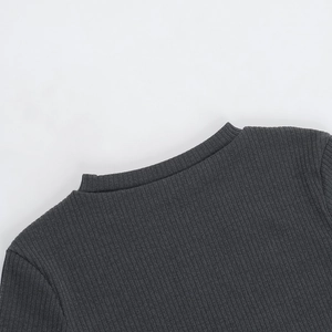 Detail view of deep grey ribbed knit fabric texture on the elegant slim-fit mini dress