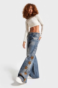 Detail of high waist wide leg jeans with orange flower hollow out embroidery on the side