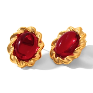Detailed macro view of vintage gold earrings with oval red gems and twisted rope texture