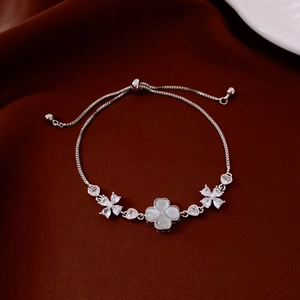 Close-up of adjustable silver flower bracelet with opal stone on a red velvet background