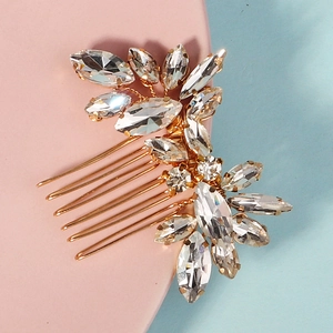 Detailed close-up of bridal hair comb with golden alloy leaves and marquise rhinestones