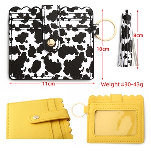 Detail view of scalloped PU leather card holder with cow print and tassel keyring
