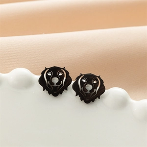 Detailed close-up of black dog head stud earrings on a white wavy porcelain plate