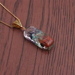 Detailed close-up of a heart-shaped pendant with colorful stones wrapped in copper wire