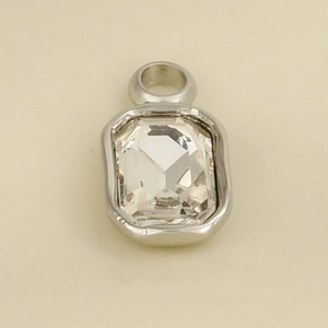 Macro shot of rectangular silver stainless steel pendant with large faceted clear crystal