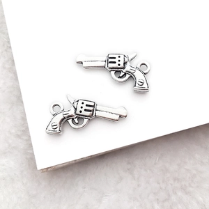 Macro shot of two vintage silver revolver alloy charms for DIY jewelry making