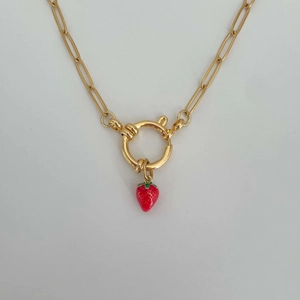 Close-up of golden chain necklace with spring clasp and red strawberry charm