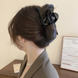 Side view of a large black glossy hair claw clip holding hair in a sleek hairstyle