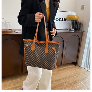 Detailed view of a vintage geometric patterned tote bag held by a model in a blazer