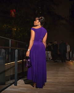 Detail of elegant off-shoulder deep purple dress with matching silk-like texture handbag