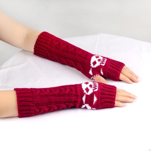 Detail of red cable knit arm warmers featuring white skull pattern and fingerless design