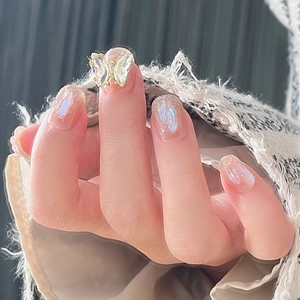 Close-up of translucent iridescent press-on nails featuring a 3D butterfly accent