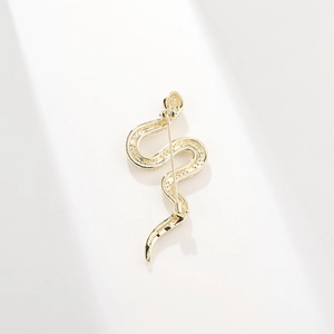 Detailed view of a gold snake brooch inlaid with sparkling cubic zirconia on white background