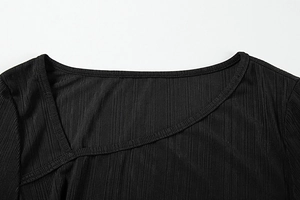 Detail of the chic asymmetrical cross wrap neckline on a black ribbed knit dress
