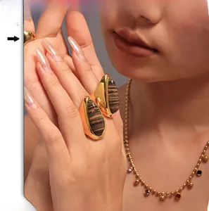 Close-up of teardrop-shaped wood grain stone ring with 18K gold plating on model