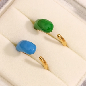 Detail of adjustable gold water drop rings with green and blue enamel in velvet box
