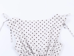 Close-up of French vintage style polka dot top featuring tie-up straps and smocked waist