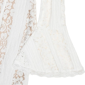 Detail shot of elegant white lace dress featuring flared sleeves and intricate patterns