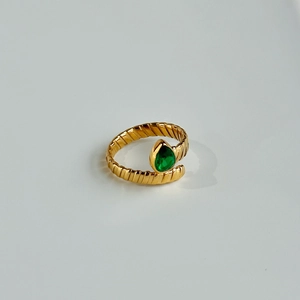 Detailed view of green pear-shaped zircon on golden spiral textured titanium steel ring