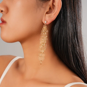 Gros plan de boucles d'oreilles pendantes dorées avec anneaux et zircon sur le mannequin