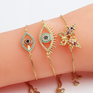 Detail of adjustable evil eye and butterfly bracelets with colorful cubic zirconia