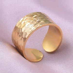 Detailed view of golden 304 stainless steel ring with hammered texture on purple silk