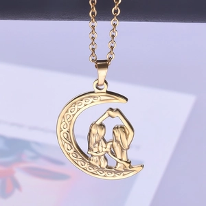 Macro detail of gold crescent moon necklace with Celtic knot and heart hand gesture