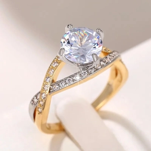 Macro shot of two-tone twisted engagement ring with brilliant round center stone