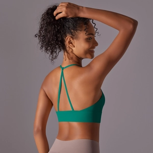 Emerald green halter sports bra with criss-cross back straps and high-stretch fabric