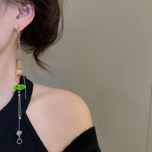 Detail of long tassel beaded earring with marble texture and wood beads on a model