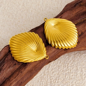 Golden 304 stainless steel shell pendants with detailed texture on dark wood
