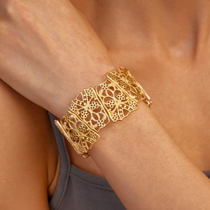 Close-up of matte gold hollow flower cuff bracelet on model with detailed texture