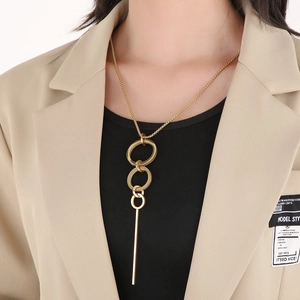 Long gold geometric pendant necklace with triple nesting rings and vertical bar on model