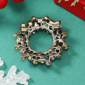 Detailed back view of vintage gold Christmas wreath brooch with red rhinestones