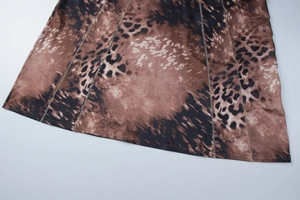 Close-up of leopard print dress hem featuring brown fabric and detailed stitching