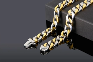 Detail of two-tone gold and silver Cuban chain link bracelet with square box clasp